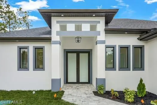 Entrance to property featuring stucco siding and a shingled roof