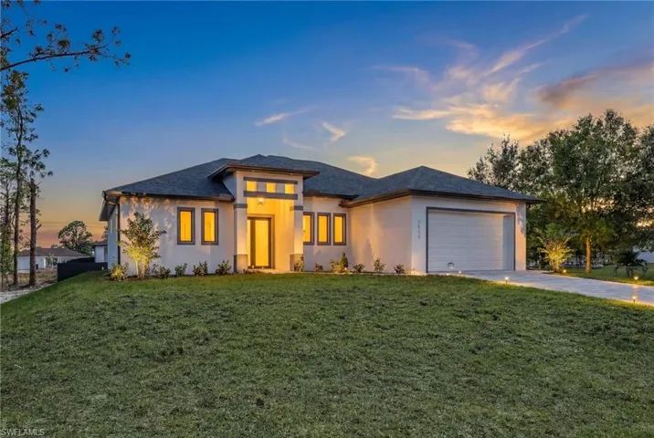 Modern exterior with a stucco finish, attached garage, and a concrete driveway
