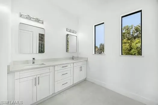 Full bath featuring double vanity and finished concrete floors