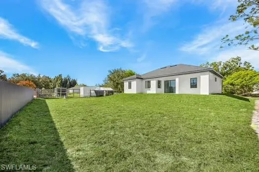 Rear view of property with a fenced backyard and stucco siding