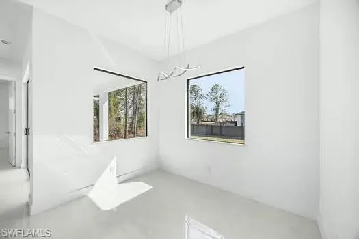 Unfurnished dining area with concrete floors and a chandelier