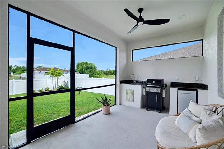 Lanai with outdoor furnishings, ceiling fan, grill, and sink