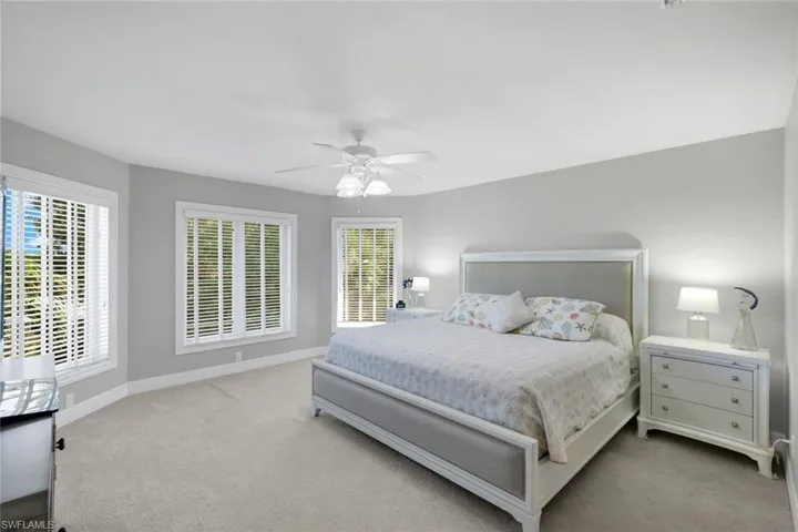 Carpeted bedroom with baseboards and a ceiling fan