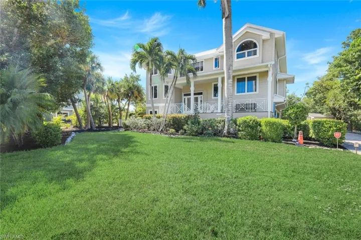 Back of property with a lawn and a porch