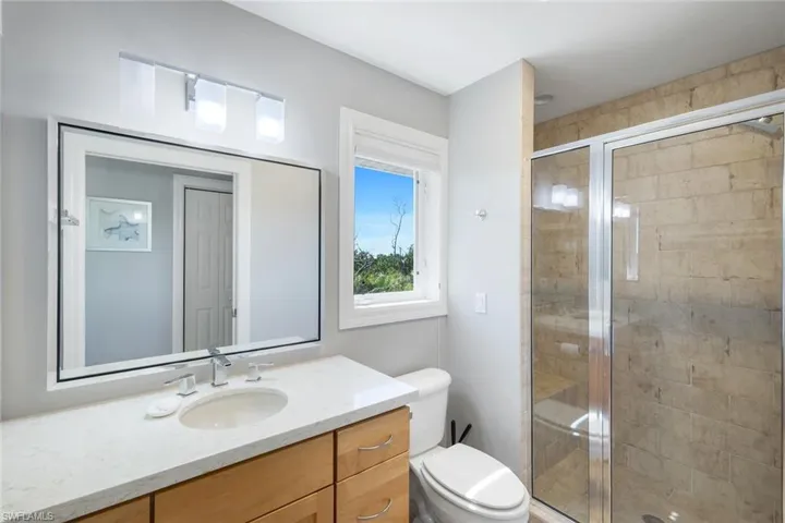 Full bathroom with vanity and a shower stall