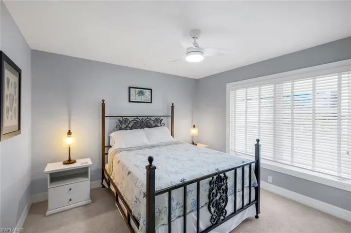 Bedroom with ceiling fan and light colored carpet
