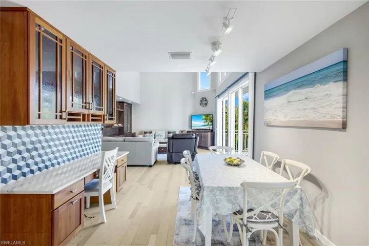 Dining room with track lighting and light wood-style floors