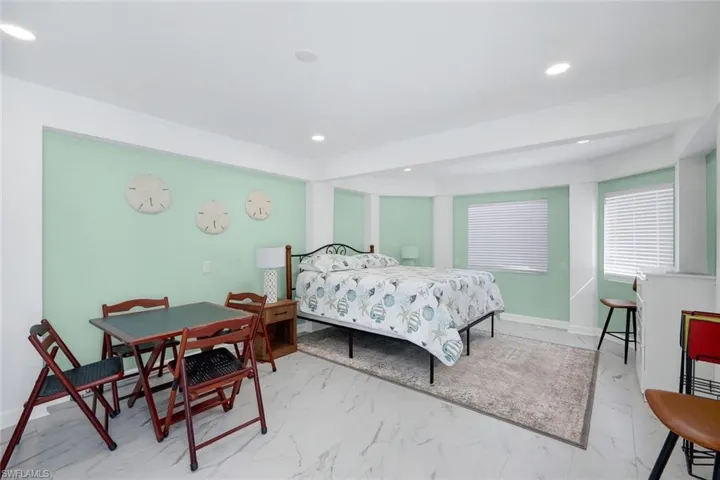 Bedroom featuring marble look tile flooring and recessed lighting