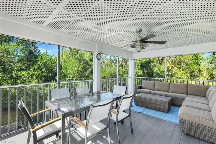 Sunroom / solarium featuring ceiling fan, outdoor dining space, and a deck