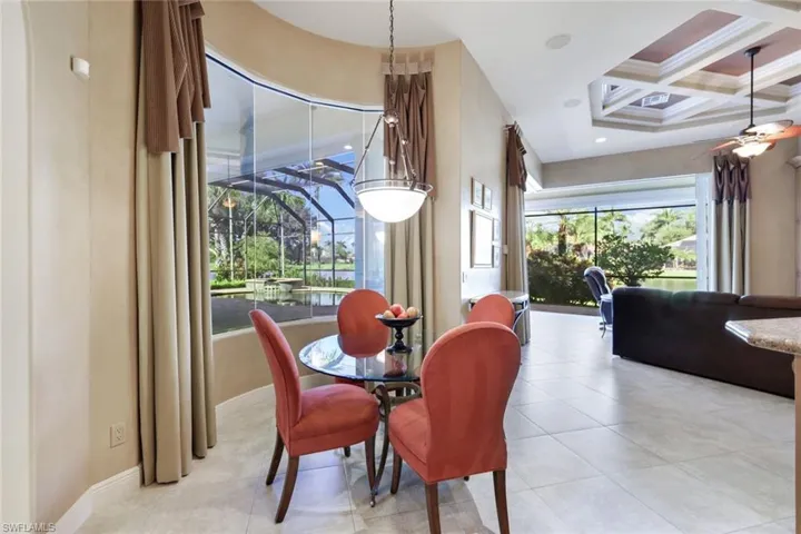 Dining room featuring coffered ceiling, light tile patterned floors, and beam ceiling