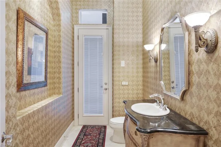 Bathroom featuring vanity, tile patterned flooring, and toilet