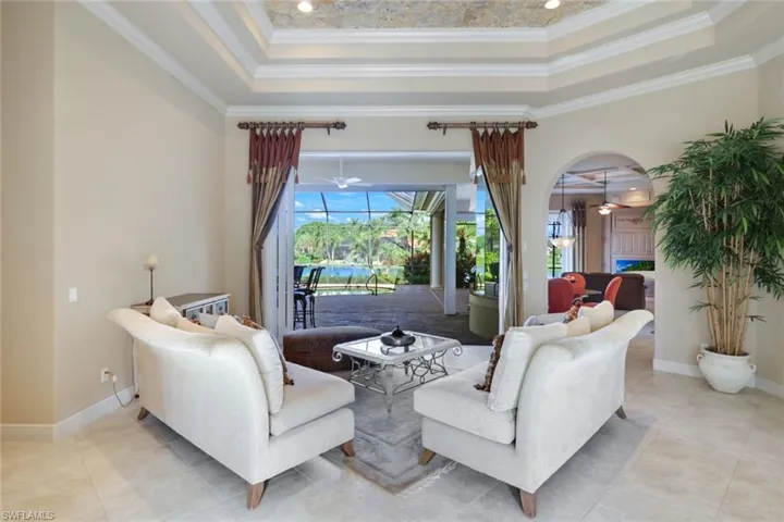 Tiled living room featuring ornamental molding and a tray ceiling