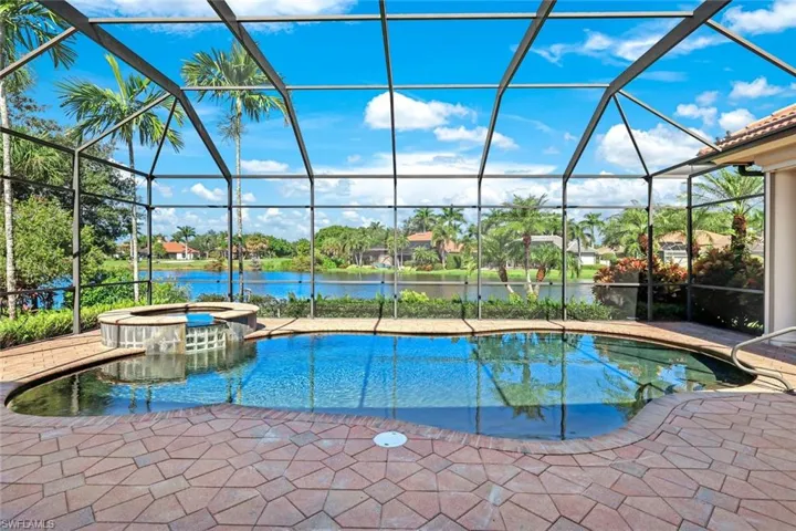 View of swimming pool with a water view, an in ground hot tub, a lanai, and a patio area