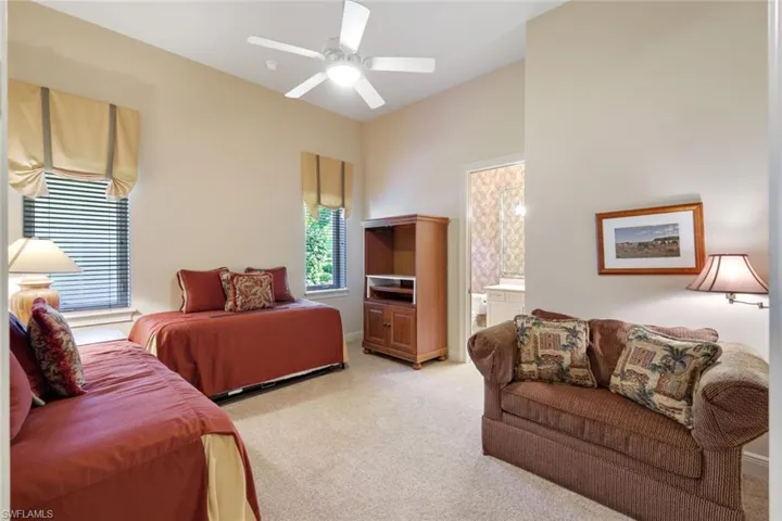 Bedroom with ceiling fan and light colored carpet