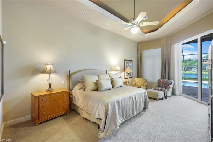 Carpeted bedroom featuring access to outside and ceiling fan