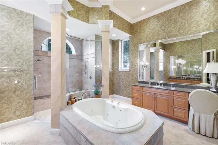 Bathroom with crown molding, ornate columns, plenty of natural light, and separate shower and tub