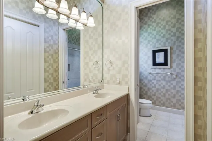 Bathroom featuring vanity, toilet, and tile patterned floors