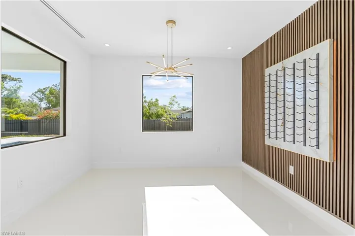Empty room with a notable chandelier and recessed lighting