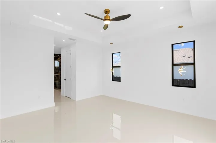 Spare room with a ceiling fan, visible vents, recessed lighting, and a raised ceiling