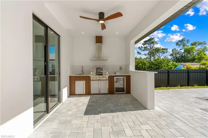 View of patio / terrace featuring wine cooler, a sink, fence, area for grilling, and ceiling fan