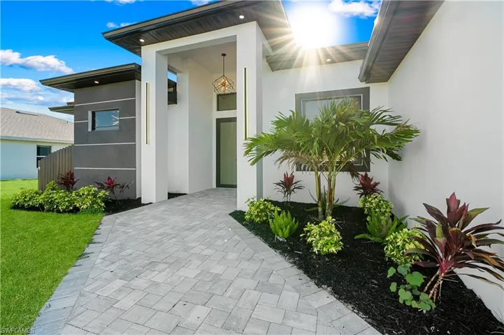 Property entrance with a lawn and stucco siding