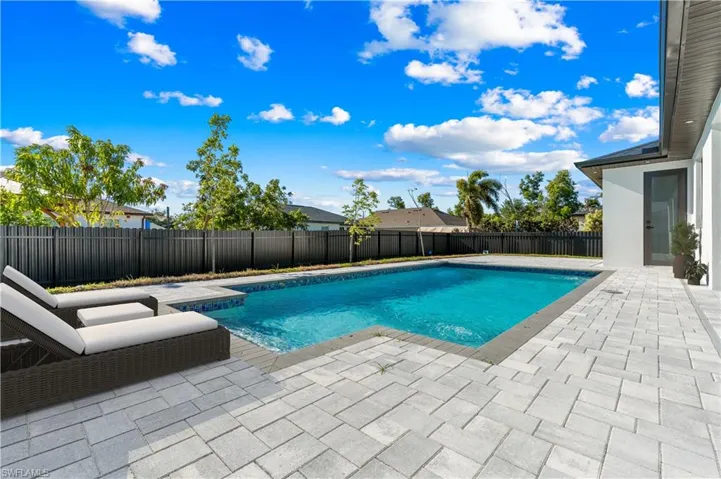 View of swimming pool with a patio and a fenced backyard