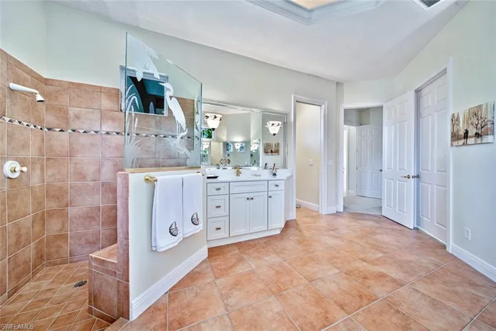 Primary bathroom features a jetted tub and also an expansive walk in shower