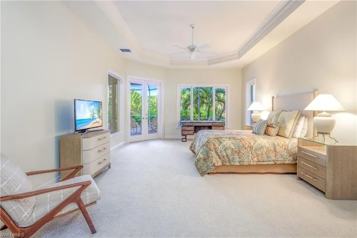 Primary Bedroom suite is serene, private, and spacious with high ceilings & a door out to the pool & spa