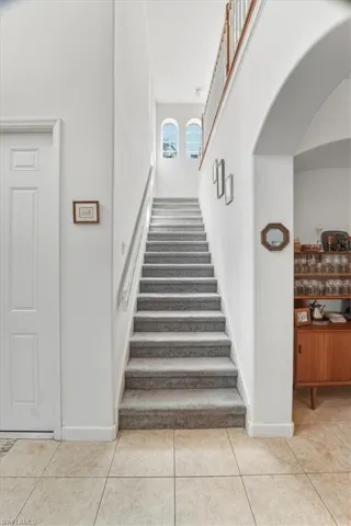 Stairway featuring a high ceiling and tile patterned floors