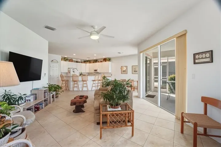 Living room with ceiling fan and light tile patterned floors