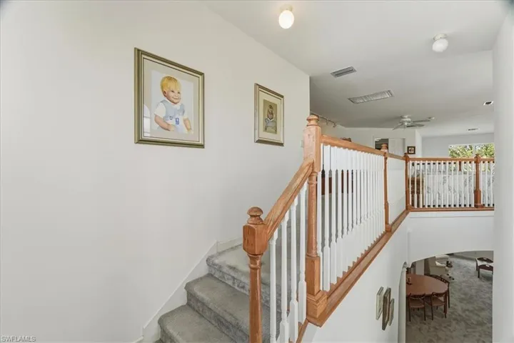 Staircase featuring carpet floors and a ceiling fan