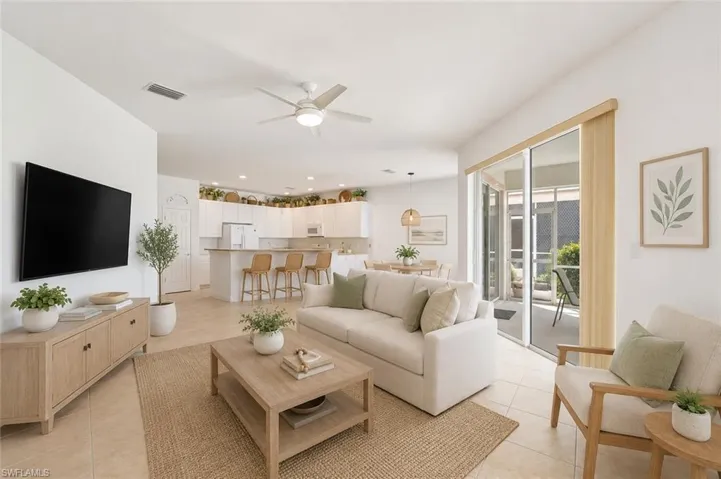 VIRTUALLY STAGED Open-concept living area featuring high ceilings, a second-story interior balcony with white balusters and wood handrail, arched doorways, a carpeted floor, and a double-door entry