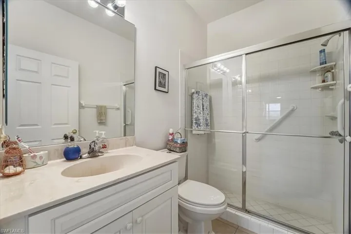 Full bathroom with vanity, a shower stall, and light tile patterned floors
