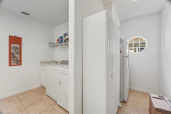 Washroom with light tile patterned floors and cabinet space