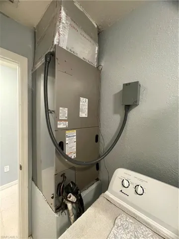 Utility area featuring a central air handler with insulated ductwork