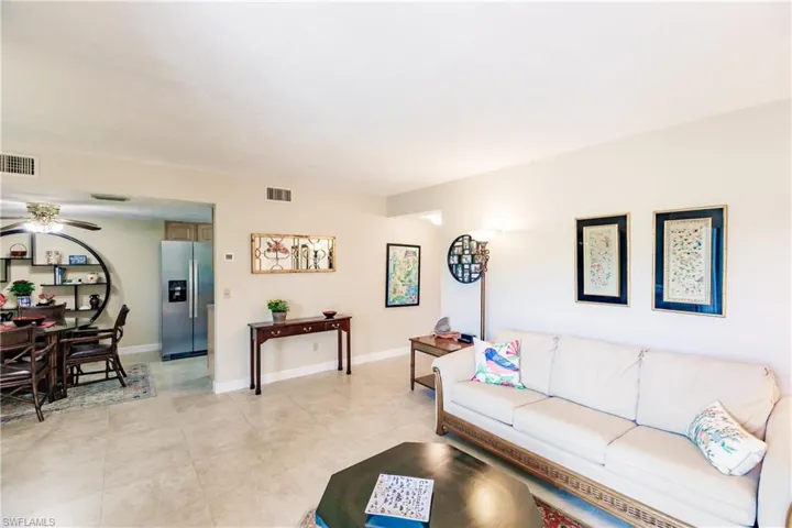 Living room with light tile patterned floors and ceiling fan