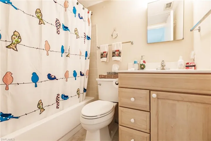 Full bathroom featuring shower / tub combo with curtain, vanity, and toilet