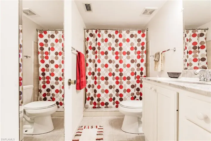 Bathroom with vanity, tile patterned floors, toilet, and walk in shower