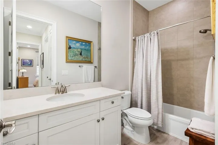 Full bathroom with vanity, shower / bathtub combination with curtain, and light wood finished floors