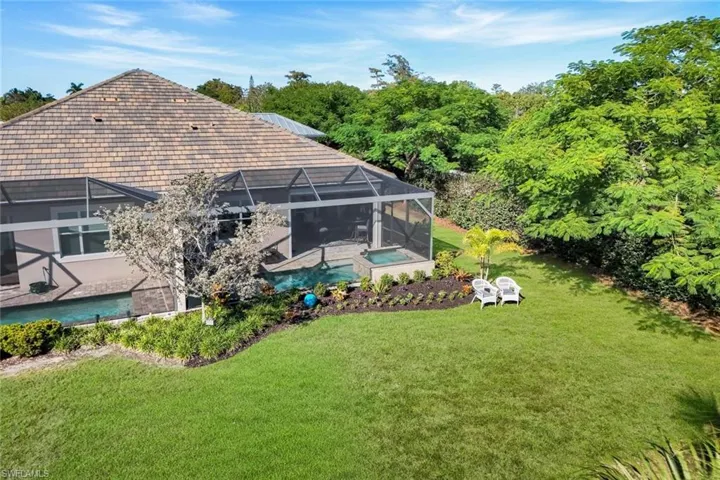Rear view of property featuring a sunroom, an outdoor pool, and a lanai
