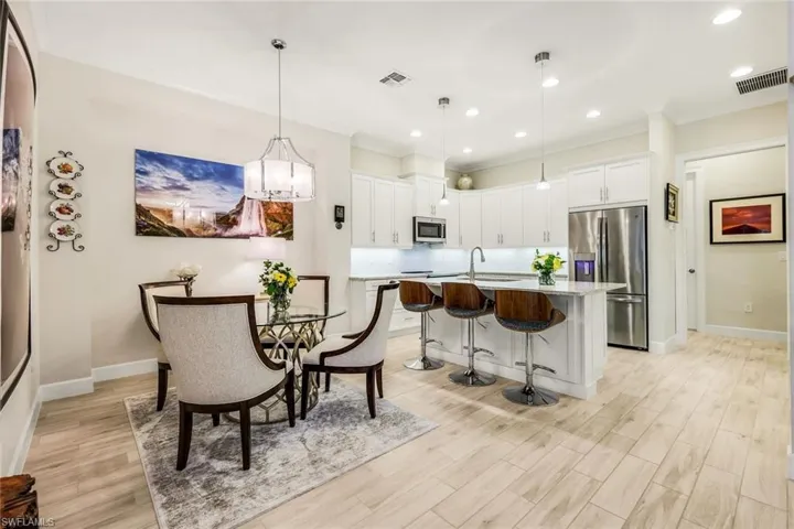 Dining area featuring light wood-style floors, recessed lighting, a chandelier, and crown molding