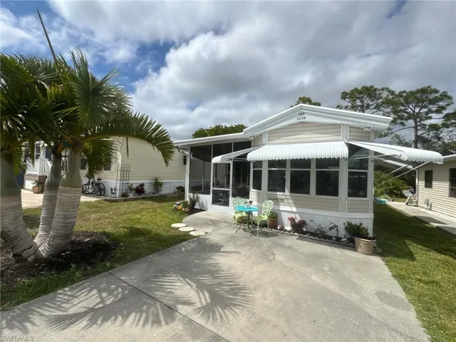 Rear view of property featuring a sunroom and a lawn