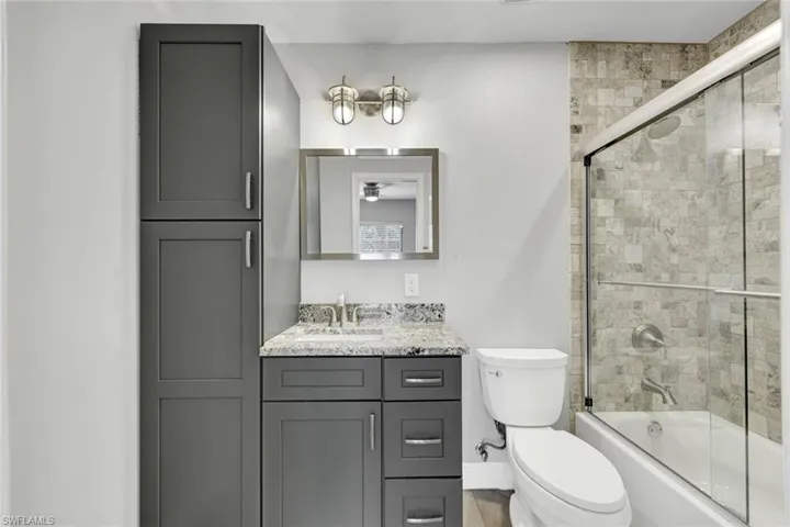Bathroom featuring a vanity with a light-colored countertop, a rectangular mirror, and a two-light fixture