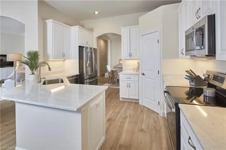 White cabinetry, quartz countertops, stainless GE Profile appliances AND a large pantry.