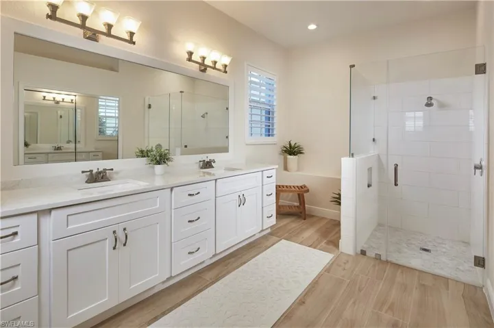 LARGE primary bathroom with new cabinetry, flooring, shower, dual sinks, and plenty of room for a vanity table.