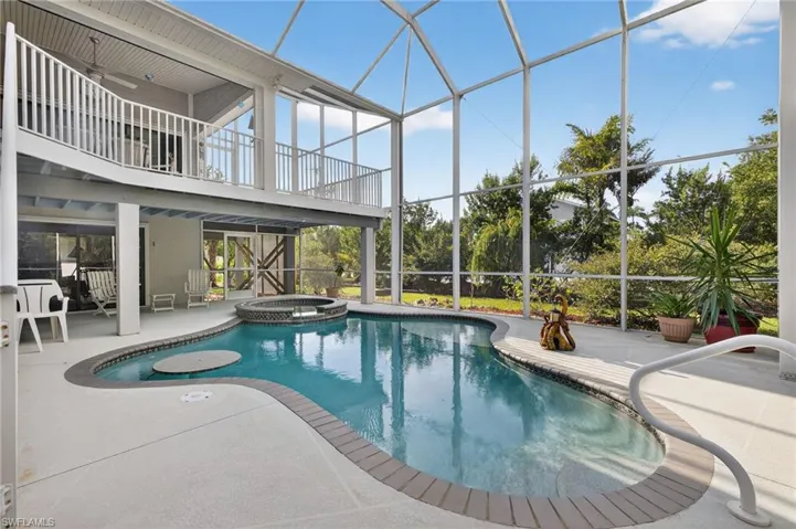 View of swimming pool featuring a sunroom, a pool with connected hot tub