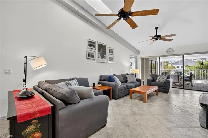 Living room featuring high vaulted ceiling, ceiling fans