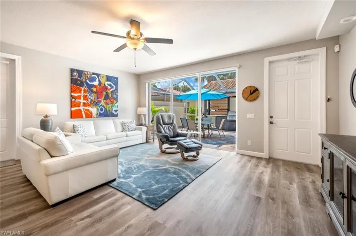 Living room featuring hardwood / wood-style flooring, ceiling fan, and a textured ceiling