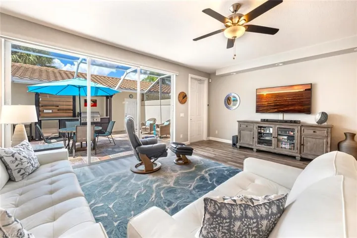 Living room with ceiling fan, plenty of natural light, and wood-type flooring