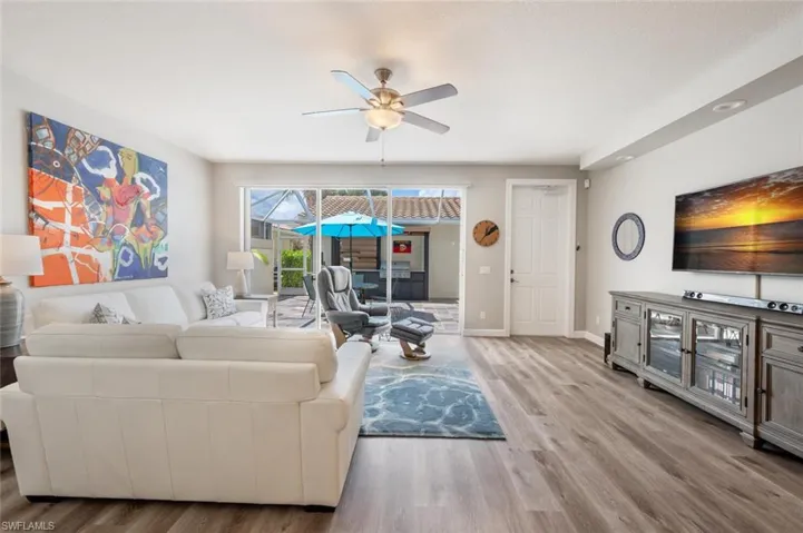 Living room with a view of the outside lanai and built in grilling area.